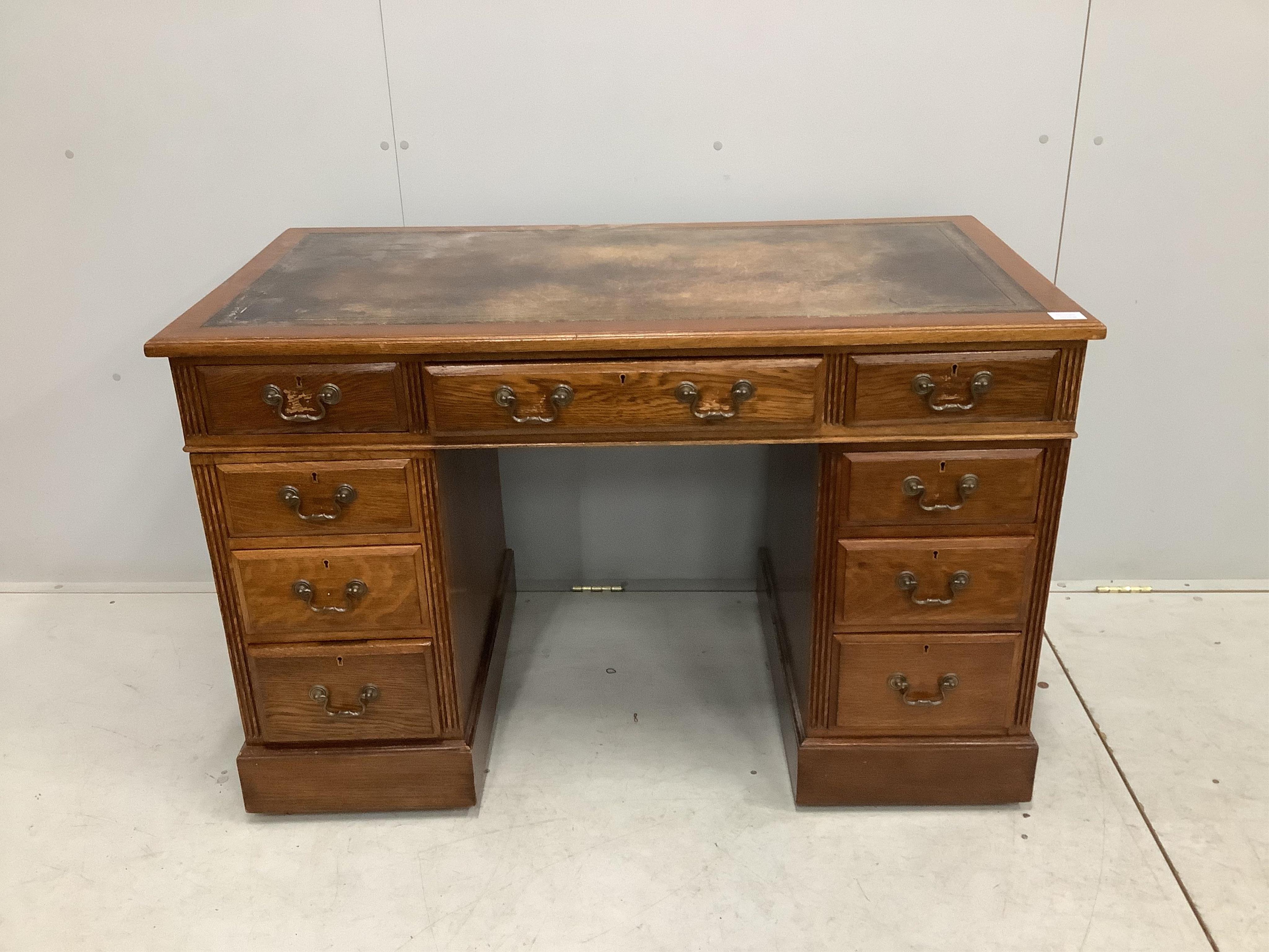 An early 20th century oak pedestal desk, fitted nine drawers, with a leather inset top, width 121cm, depth 64cm, height 78cm. Condition - fair